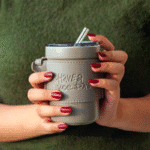 Person holding Intaryaa Slate Wander travel mug with detachable leatherette strap