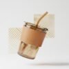 Aesthetic glass coffee tumbler with leather sleeve and straw